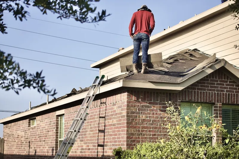 Professional roofer working on a residential roof in Marcella